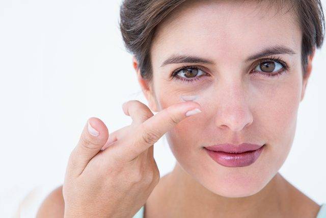 Photo of woman putting in contact lens